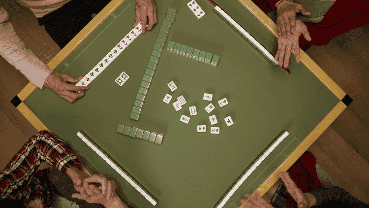 Mahjong table with four players on each side with tiles in front of them